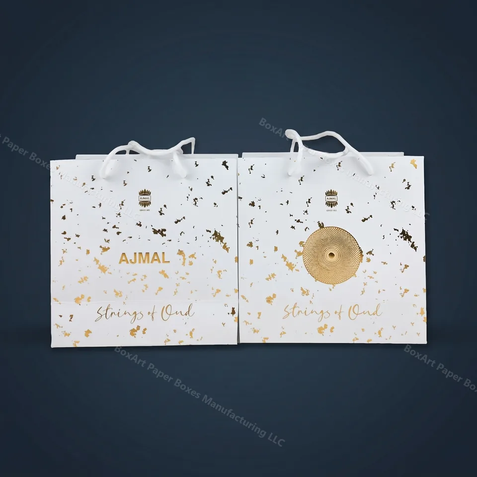 Ajmal Strings of Oud — Shopping Bags — luxury shopping bags manufactured in Dubai by BOXART — Pair of luxury shopping bags with matte-white lamination, gold-leaf fleck and rope handles for the Strings of Oud line.